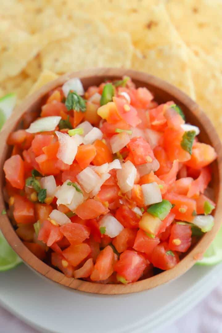 closeup of Pico de Gallo in wooden bowl with tortilla chips