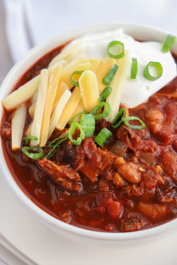 closeup of pulled pork chili in white bowl