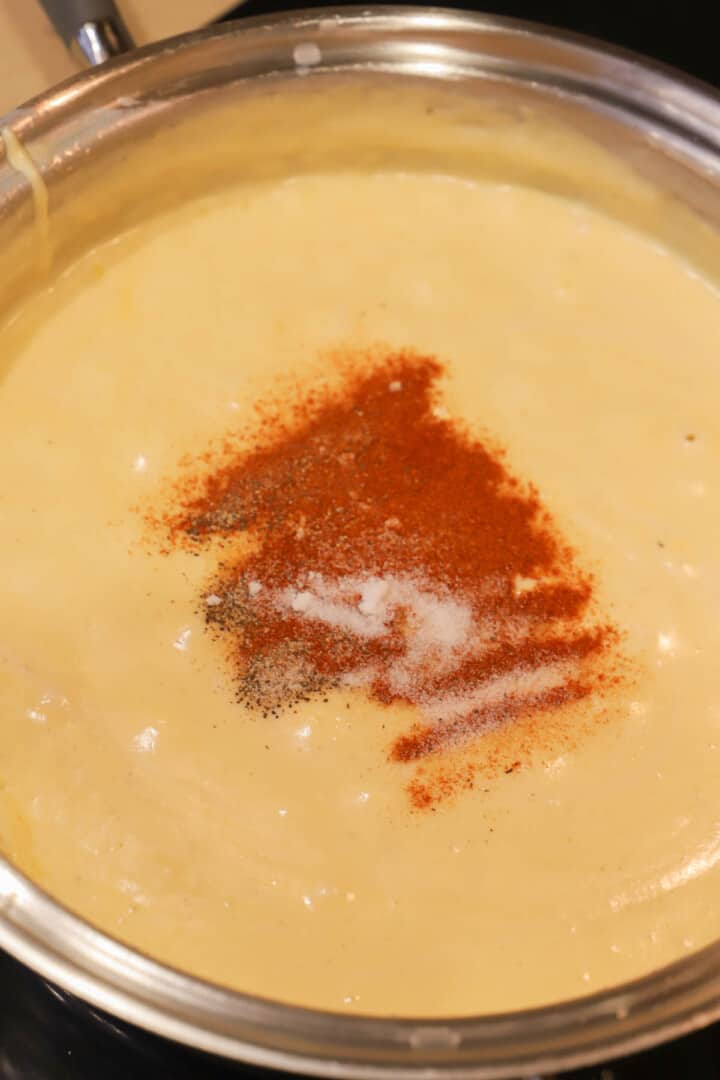 adding the spices to the cheese sauce