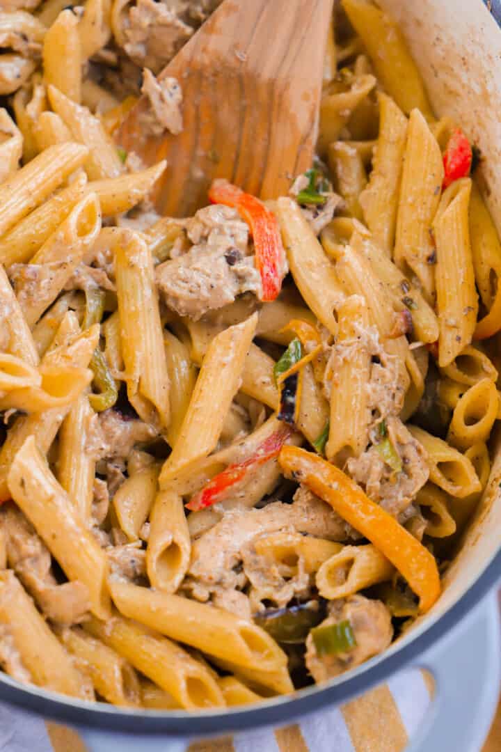 Rasta Pasta in large pot being scooped with wooden spoon