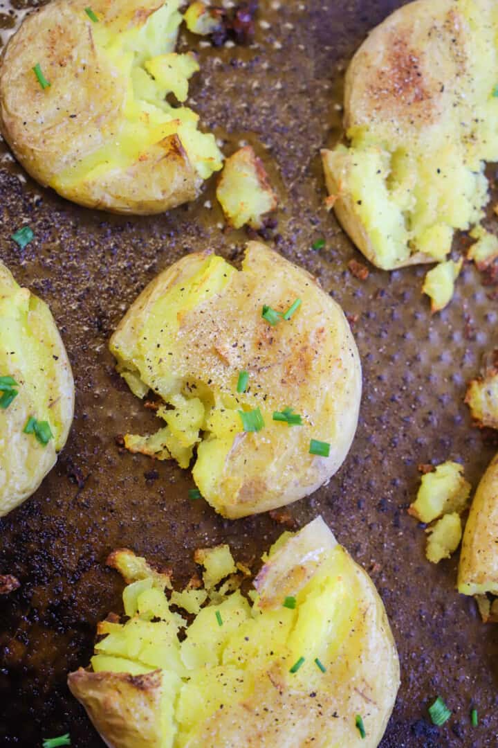 Smashed Potatoes on baking sheet topped with green onions