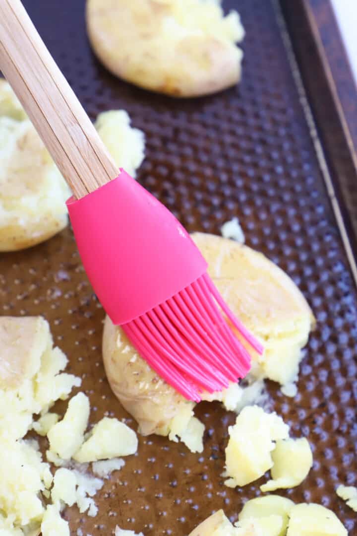 brushing oil on top of mashed potatoes.