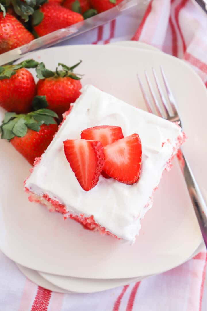 Strawberry Poke Cake Closeup on white plates 