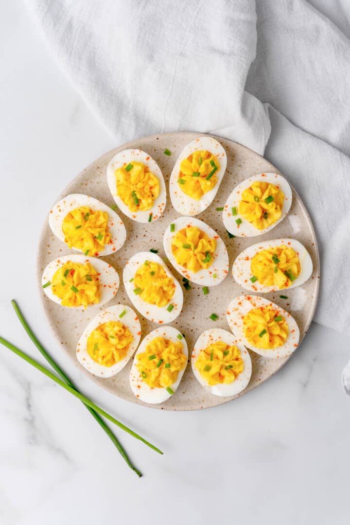 serving the deviled eggs topped with green onions
