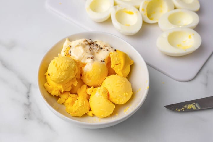 mixing the ingredients for the deviled egg filling.