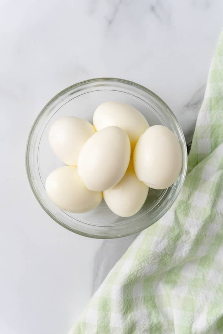 hard boiled eggs peeled in clear bowl.