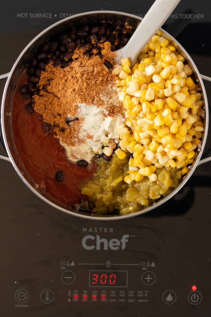 adding in remaining ingredients for taco soup