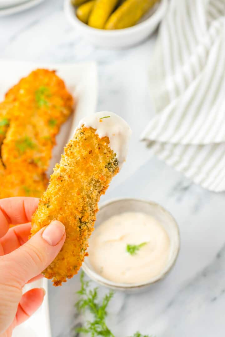 fried pickle dipped in ranch in hand.