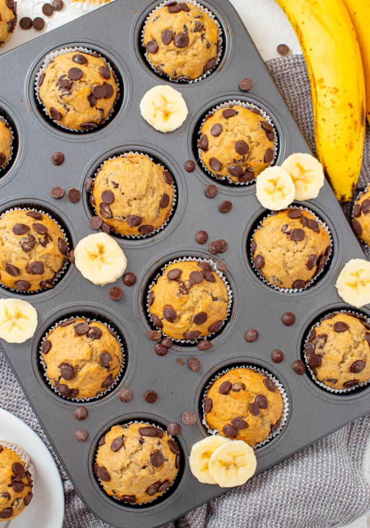baked muffins in pan with sliced bananas and chocolate chips around