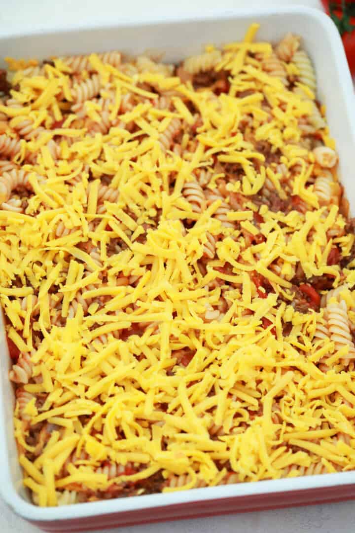 topping cheeseburger casserole with cheddar cheese