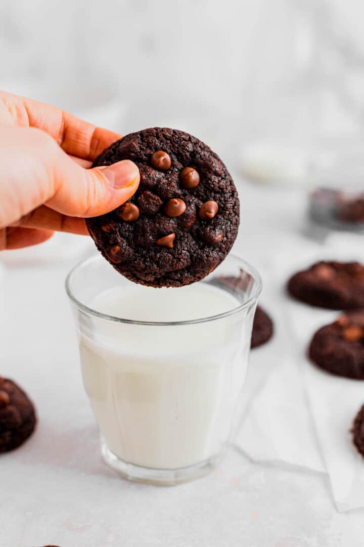 dipping cookie in a glass of milk