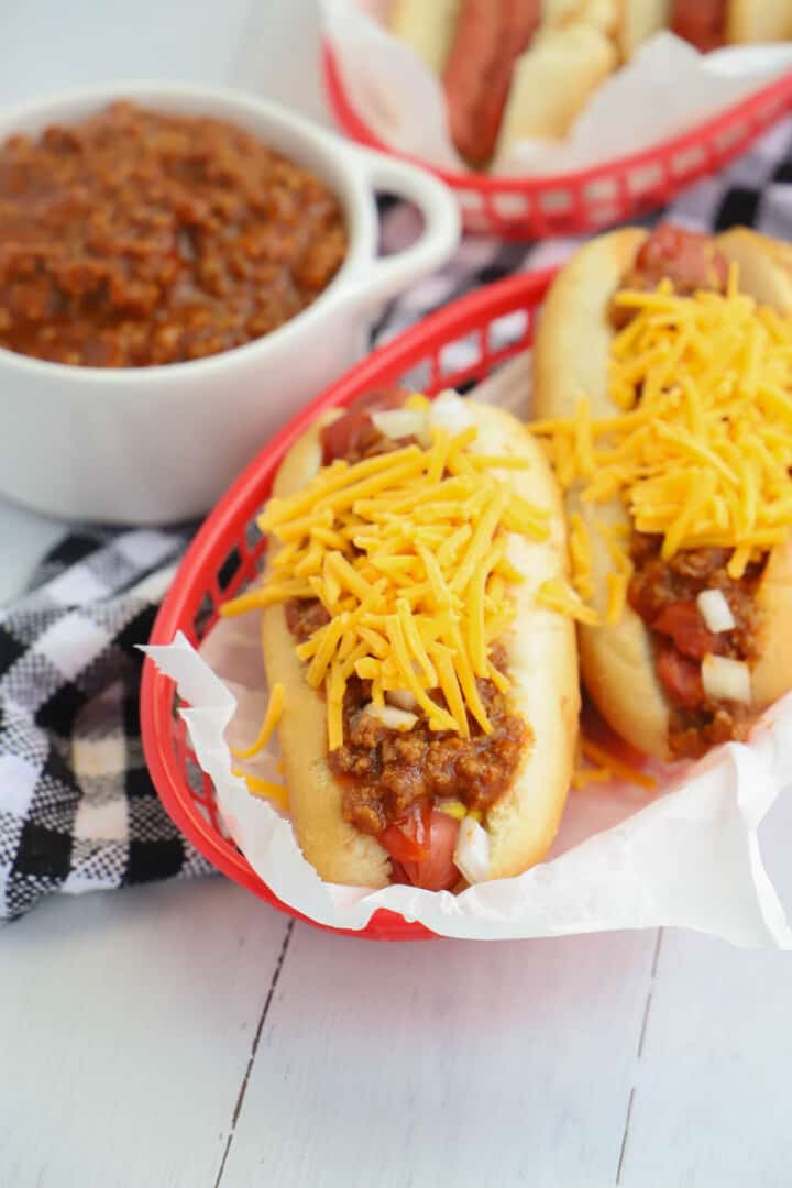 chili dogs in serving basket with bowl of chili on the side