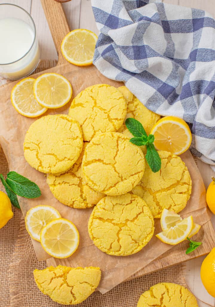 lemon sugar cookies on wooden board with milk and lemon slices around it