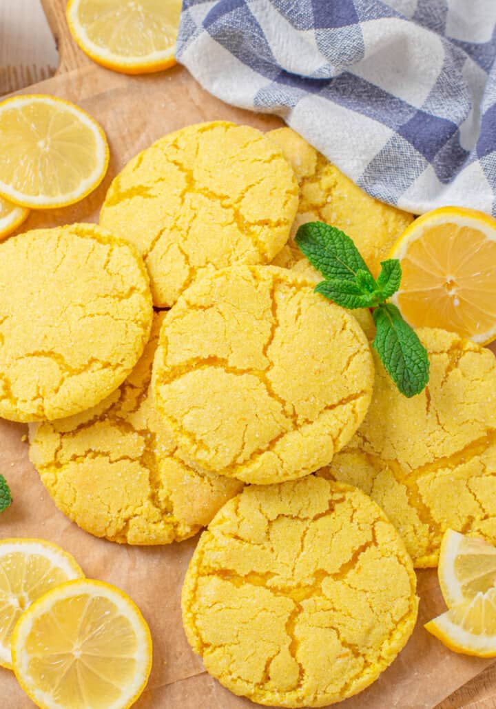 Lemon Sugar Cookies on wooden serving board with lemon slices by them