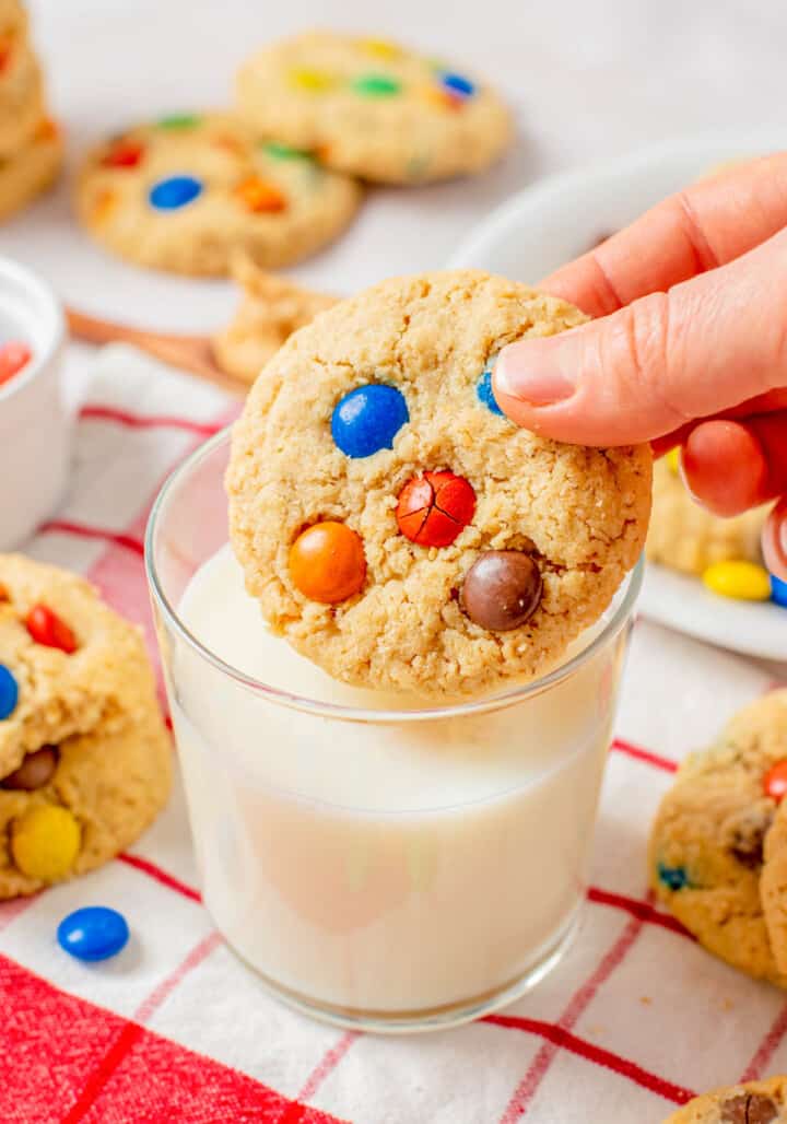 cookie in hand being dunked in milk