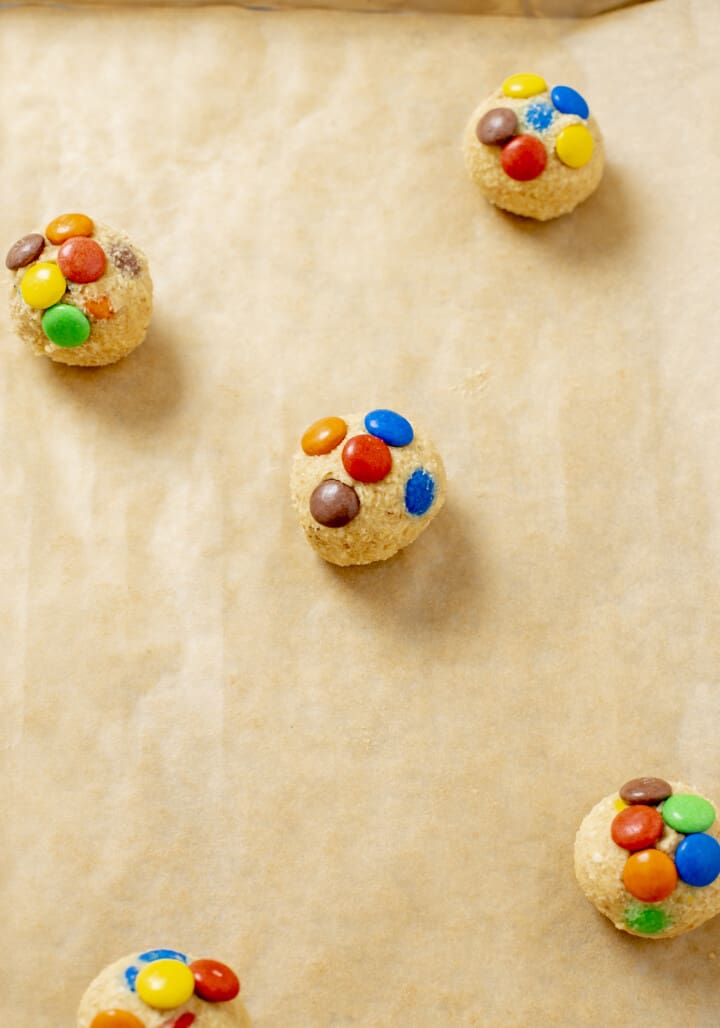 peanut butter m and m cookie dough balls on baking sheet