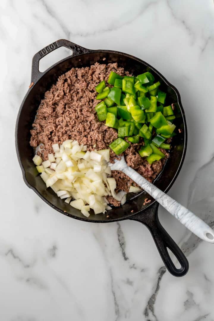 cooking beef peppers and onions in skillet