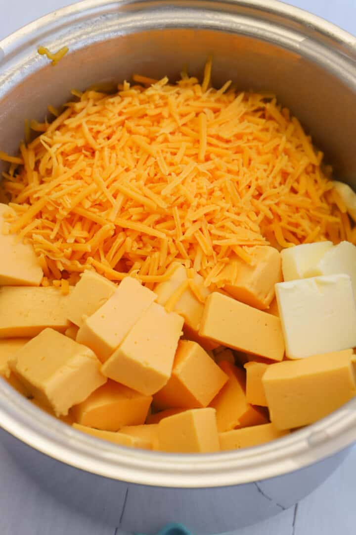adding cheese to the pot to make the cheese sauce.