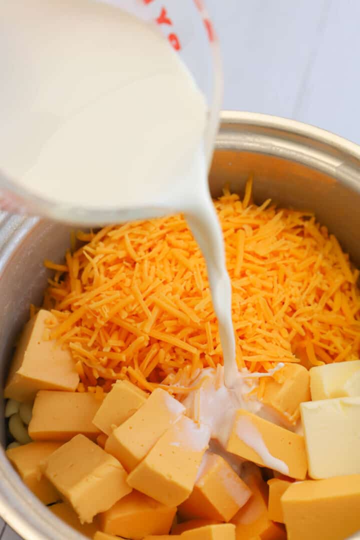 pouring milk into the pot for the mac and cheese.