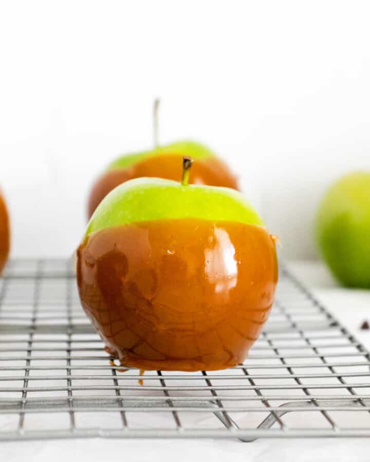 closeup of caramel apples on wire rack.