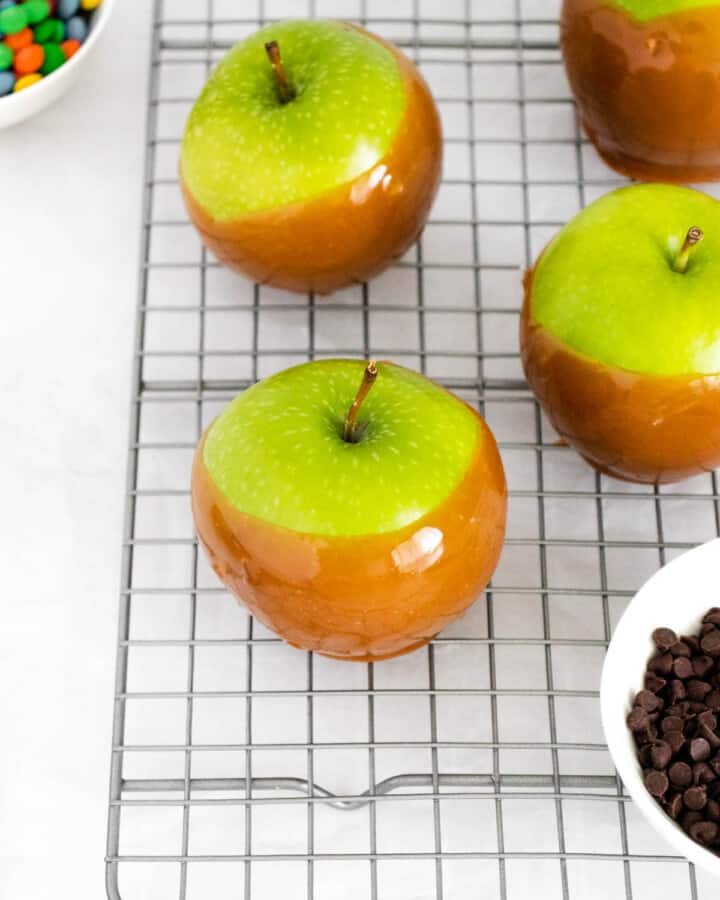 closeup of caramel apples on wire rack.