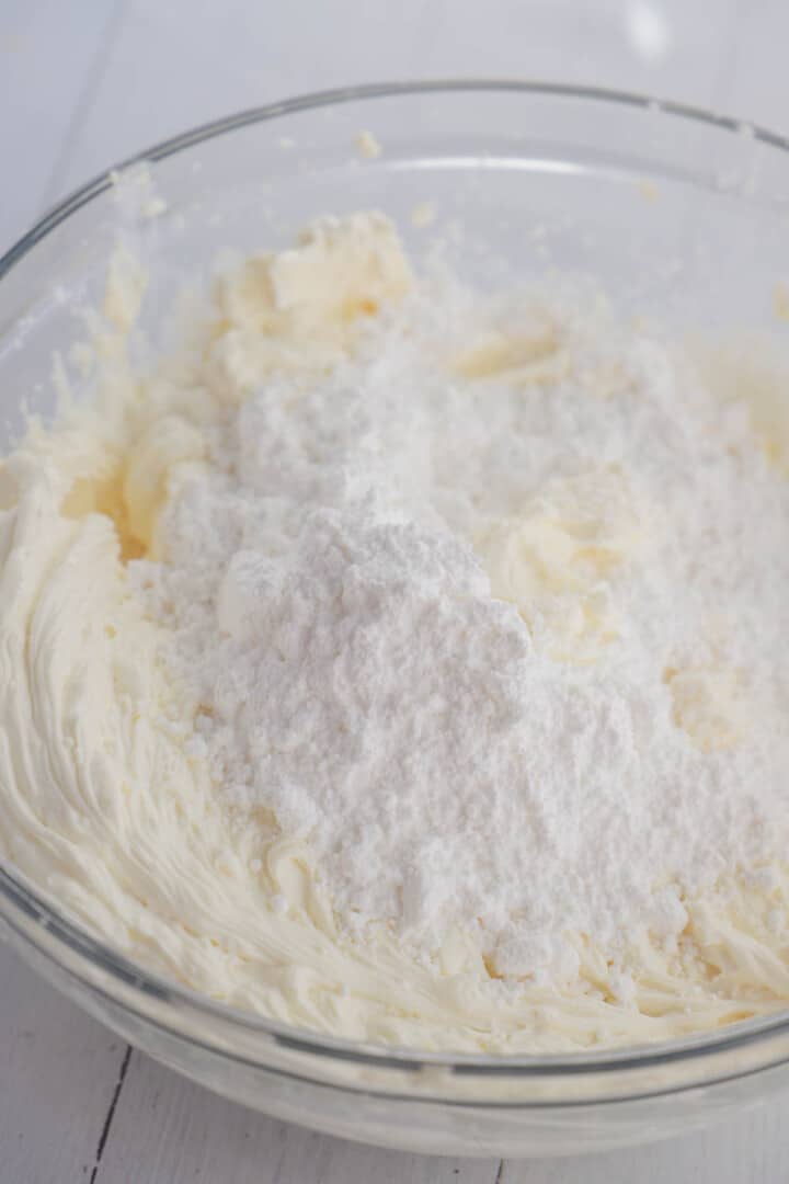 adding powdered sugar to the cream cheese