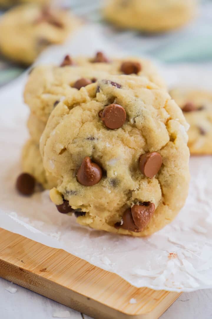 closeup of coconut chocolate chip cookie on wooden board.