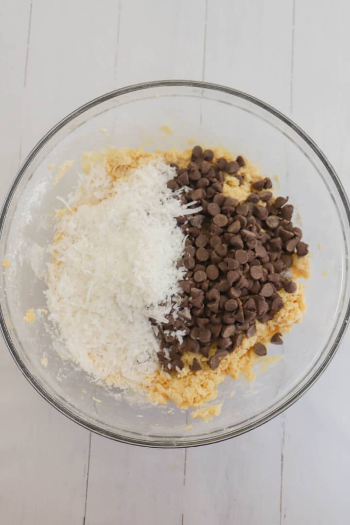 adding in the coconut and chocolate chips to the dough.