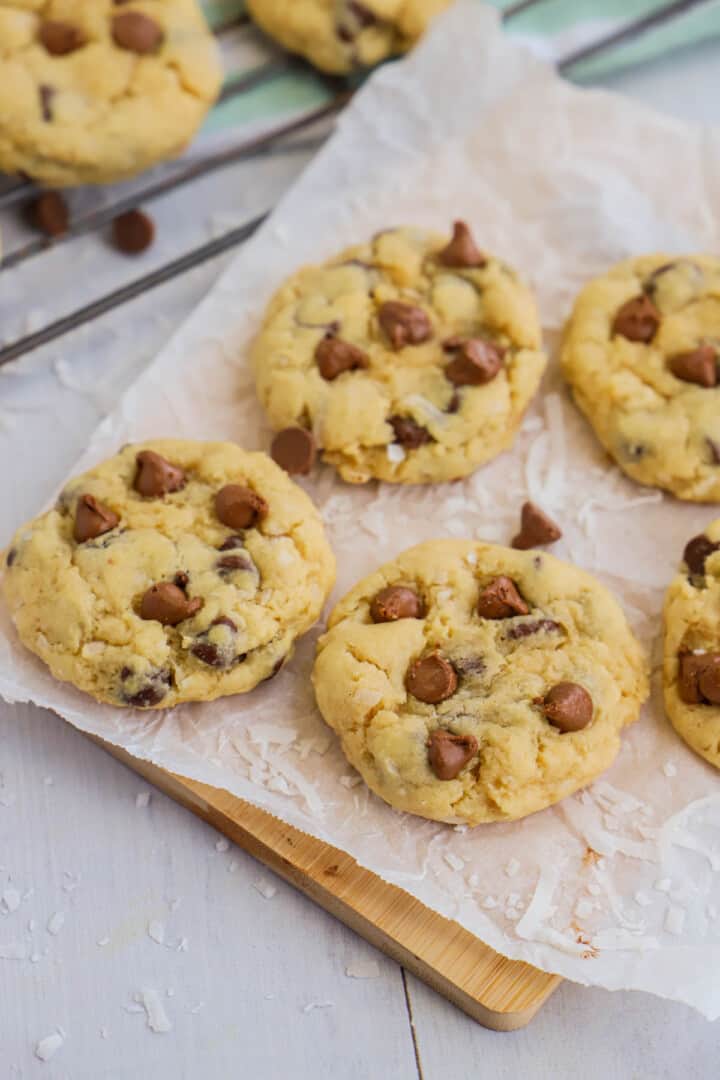 baked coconut chocolate chip cookies on rack and wooden board.