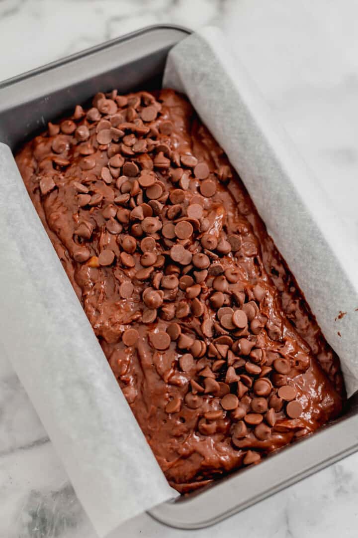 pour the banana bread batter into the bread pan and topping with more chocolate chips.