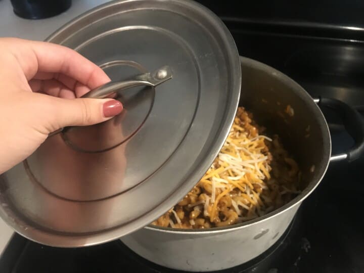 putting lid on the pot to melt the cheese.