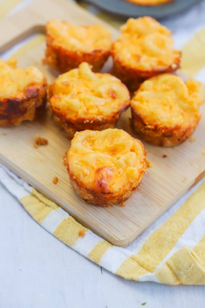 mac and cheese bites on wooden serving board.