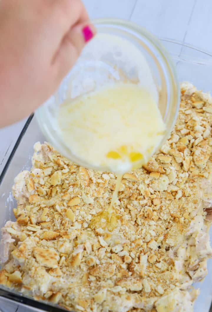 pouring butter on top of the casserole.