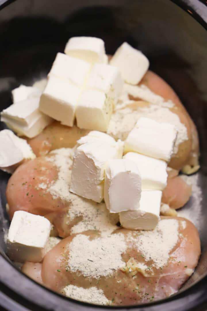 chicken, seasoning, and cubed cream cheese in slow cooker.