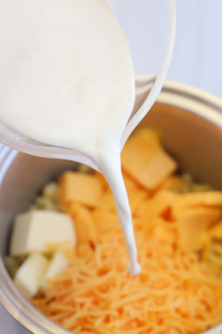 pouring milk over ingredients in large pot.