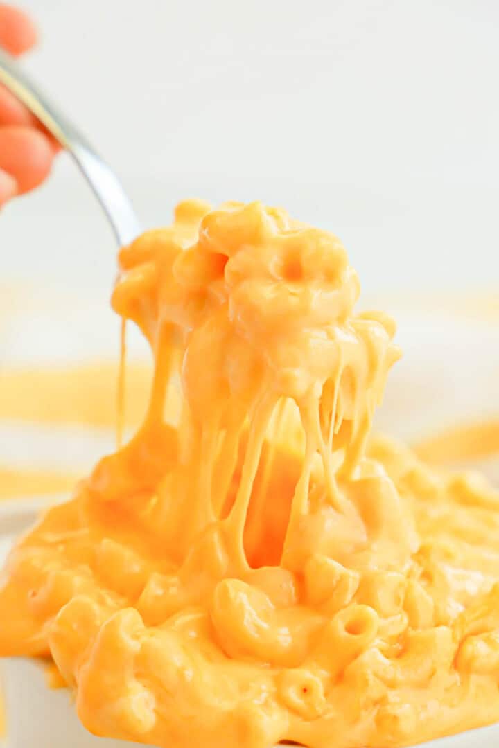 scooping out mac and cheese on a spoon.