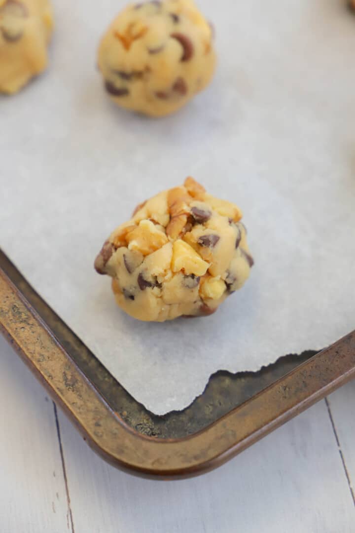 walnut chocolate chip cookie dough balls on baking sheet.