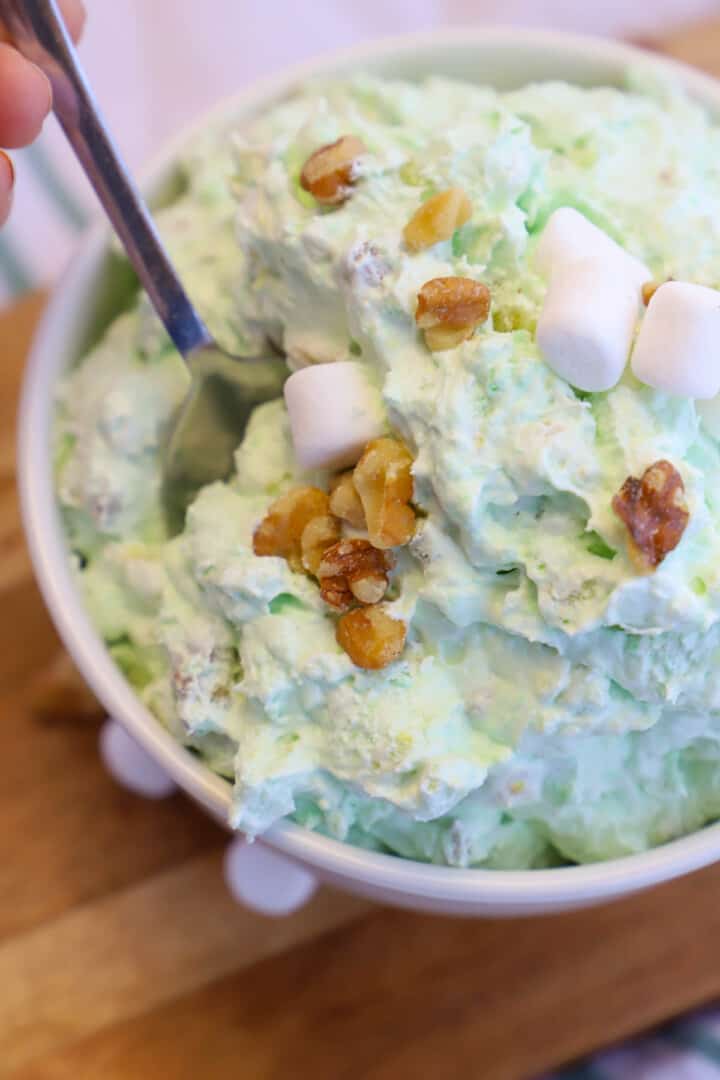 Watergate Salad in white bowl with spoon scooping it out