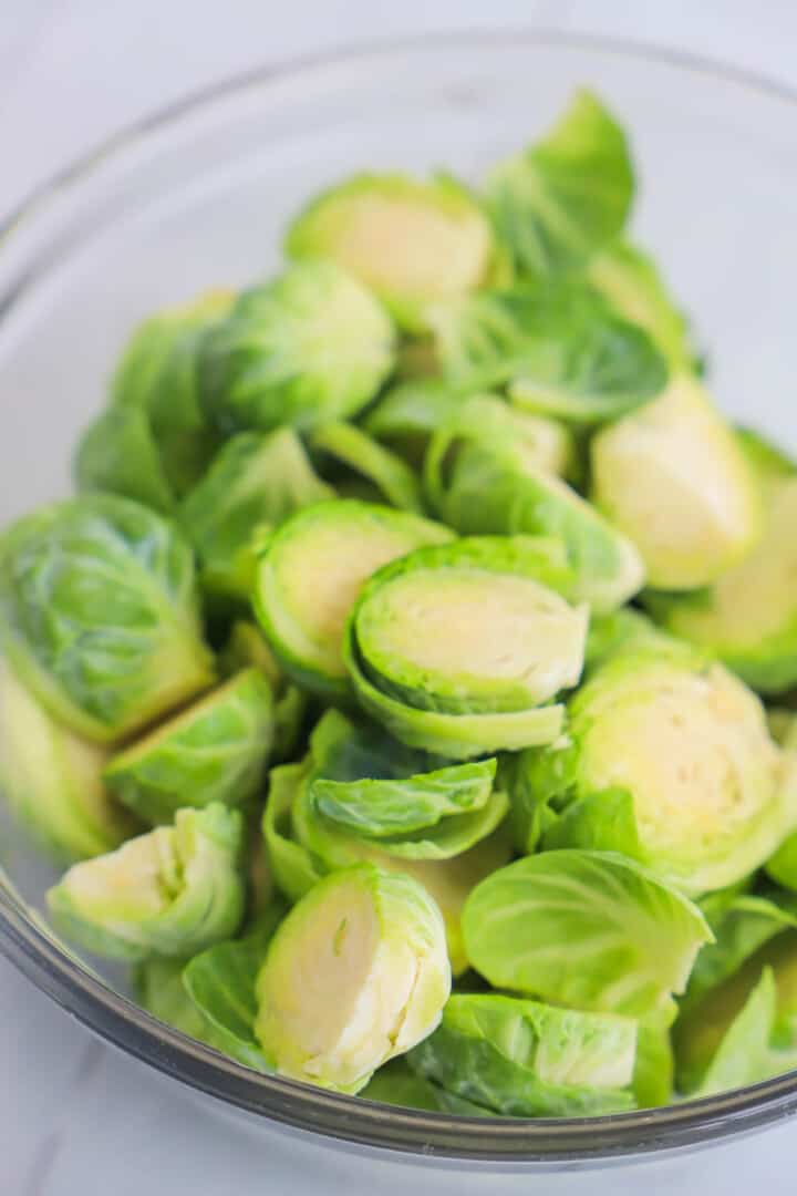 sliced Brussel sprouts in clear glass bowl.