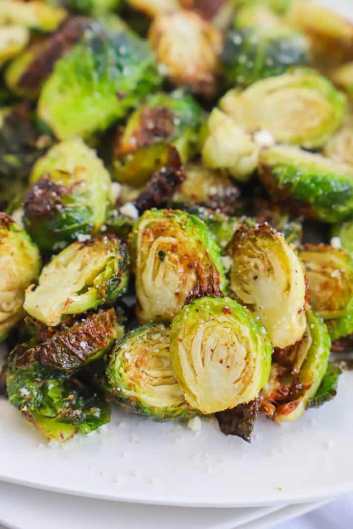 closeup of air fryer Brussel Sprouts on white plate.