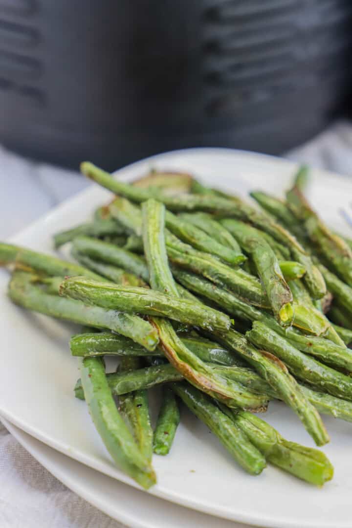 closeup of air fryer green beans on white plates.