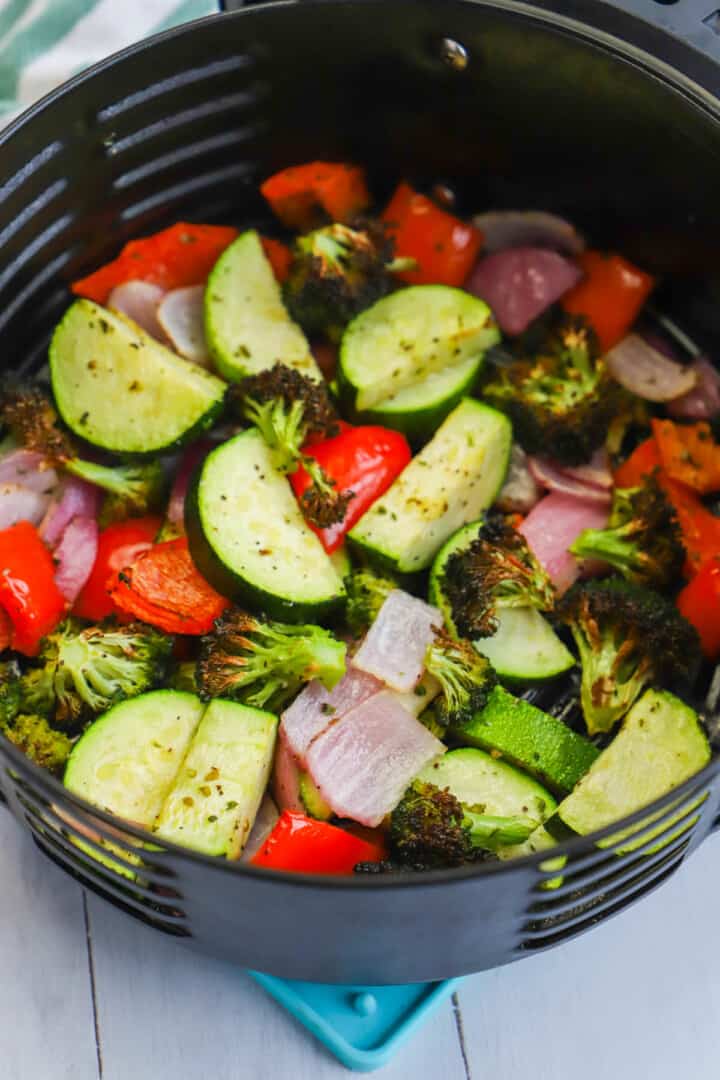cooked veggies in air fryer tray.