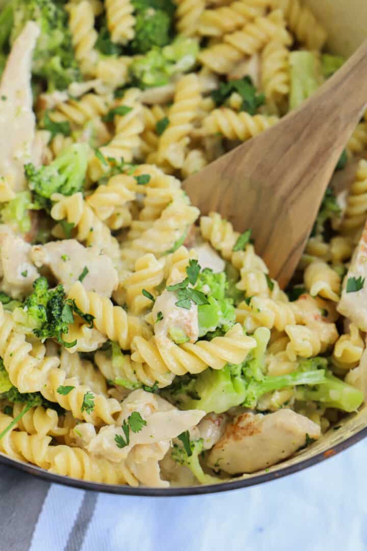 Chicken Broccoli Alfredo in large pot with wooden spoon.
