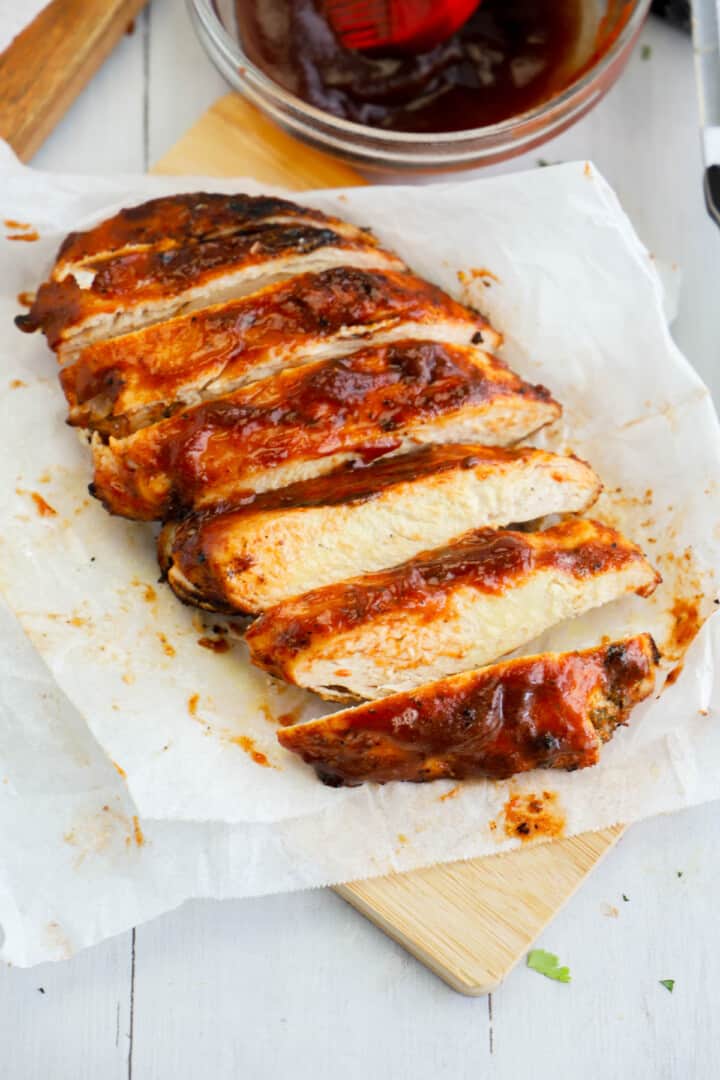 BBQ grilled chicken sliced on parchment paper.