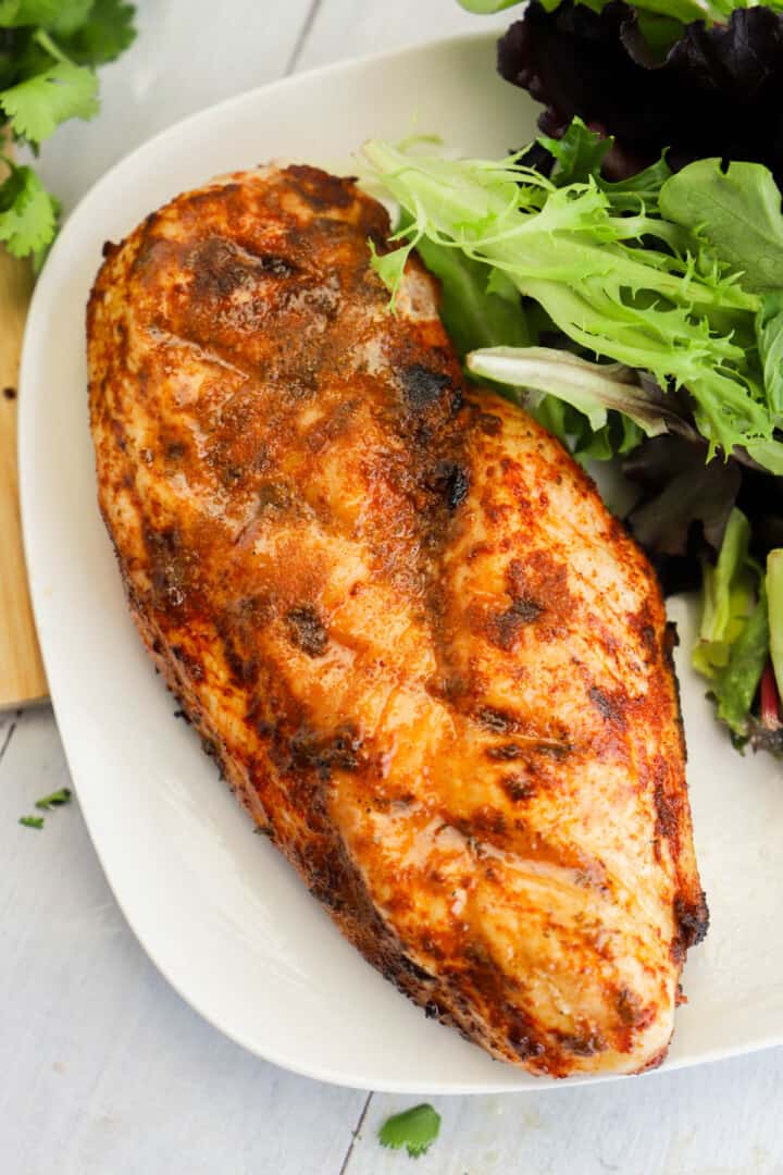 grilled chicken breast on white plate.