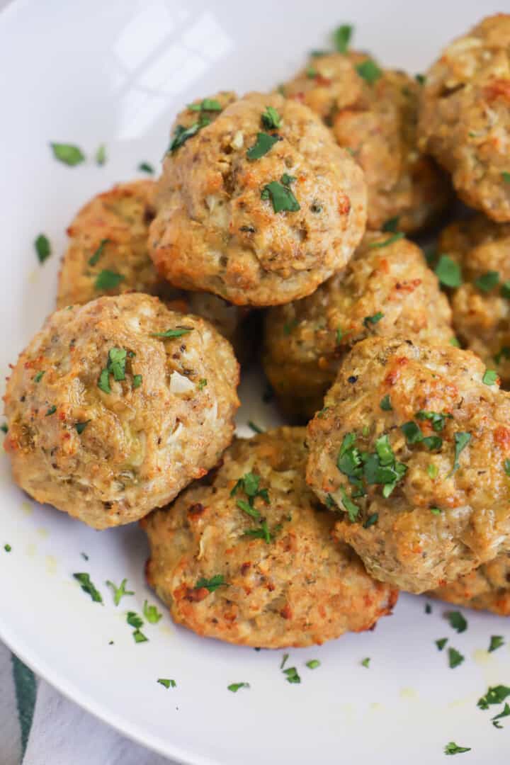 Turkey Meatballs on white serving plate sprinkled with parsley.
