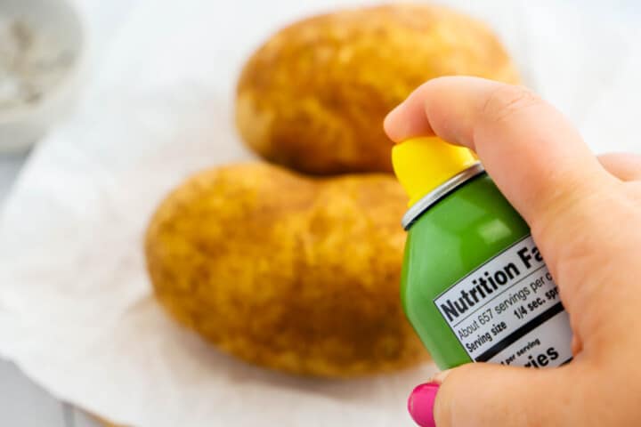 spraying the potato with oil spray.