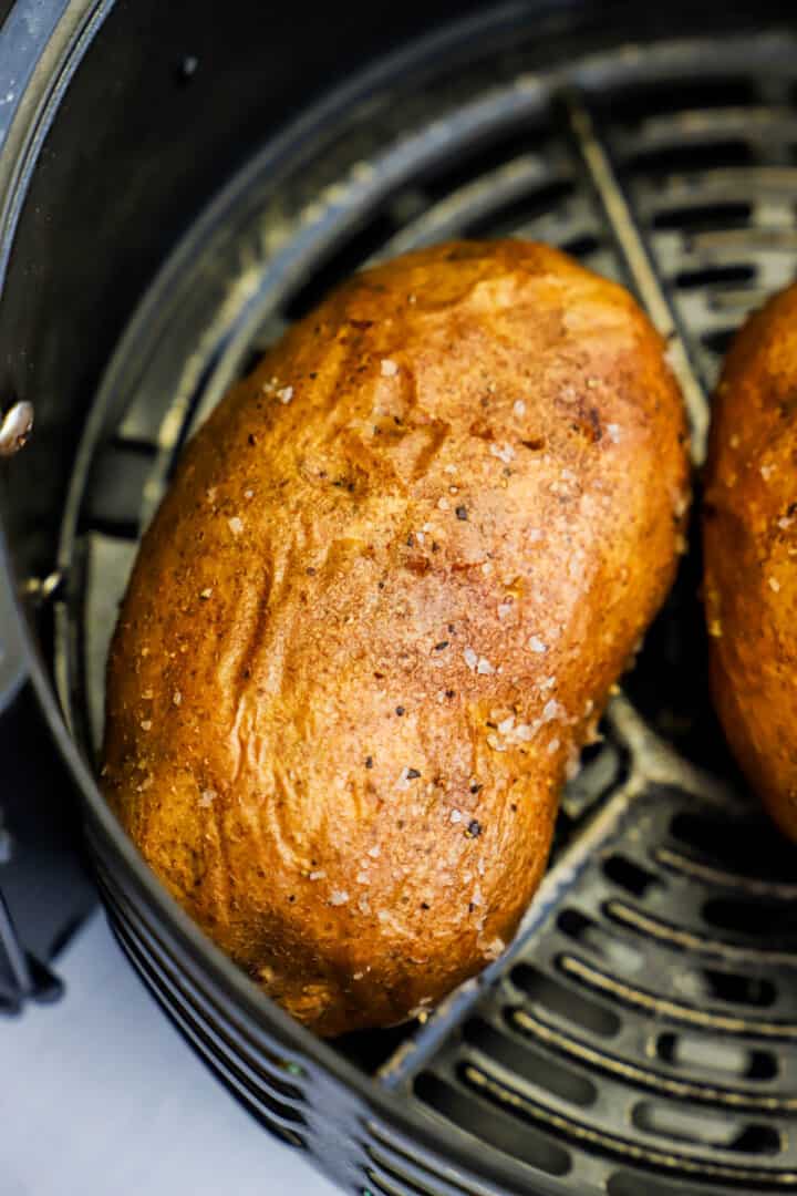 Air fryer baked potato baked in the air fryer basket.