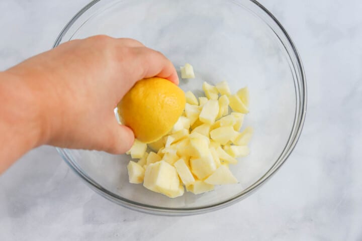 squeezing the lemon juice on the apple chunks.