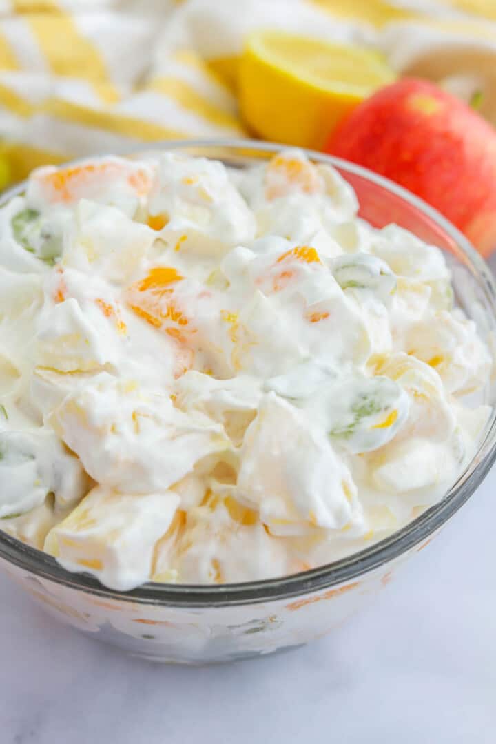 closeup of creamy fruit salad in glass bowl.